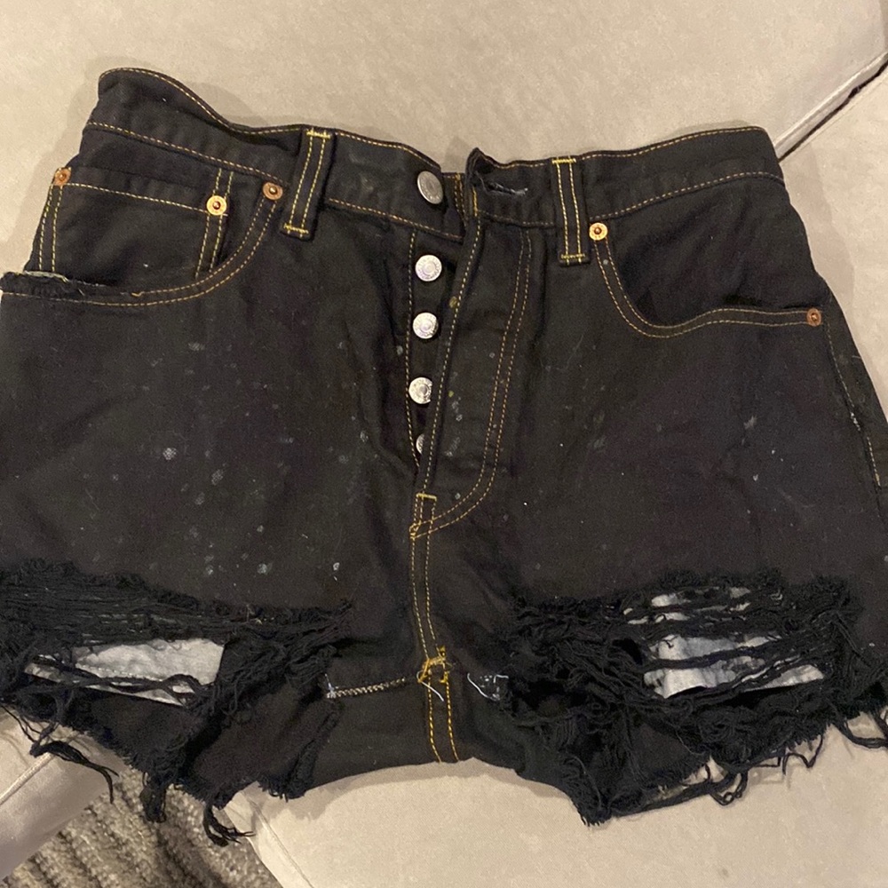 Black denim shorts with faint “splatter” detail